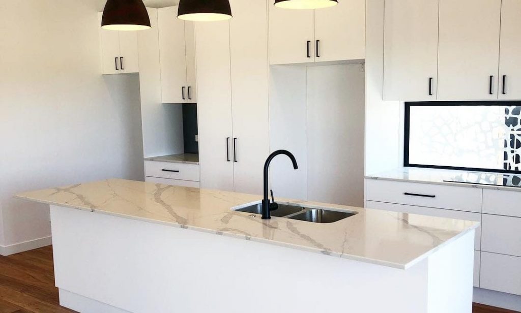 Modern Kitchen with White Cabinets and Marble Counter Island | Featured Image for New Year Plumbing Resolutions Blog by Akins Plumbing