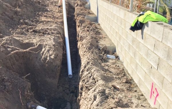 Ditch with a long PVC tube in it | Featured image for Plumbing & Drainage Renovation Project Albion.