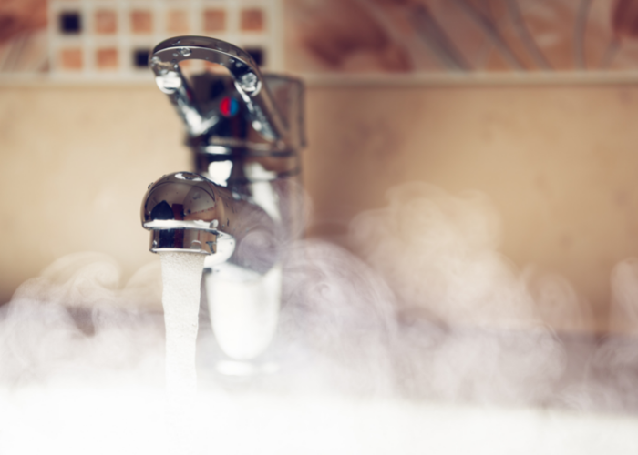 Sink pouring hot water. | Featured image for Hot Water Systems on Akins Plumbing.