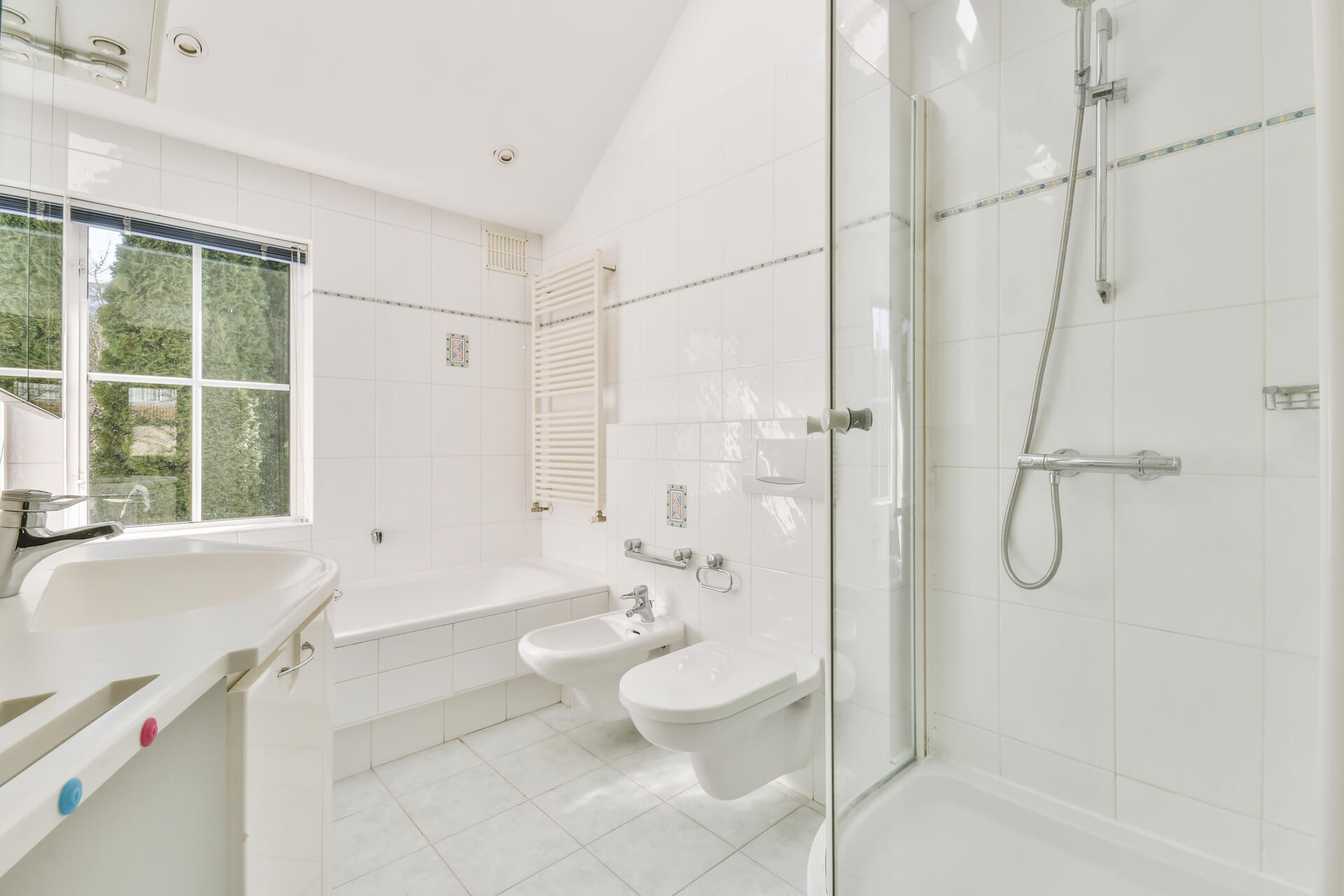 Photo of a white tiled modern bathroom | Featured image for The Modern Bathroom Accessories blog by Akins Plumbing.