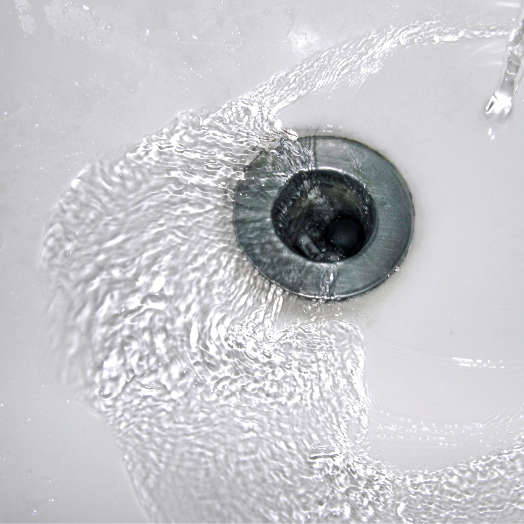 Water running down a sink. | Featured image for Causes of a Sink Blockage blog for Akins Plumbing.