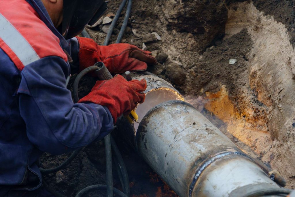 Utility worker working on underground pipes | Featured image for the Drain Repairs Service from Akins Plumbing.