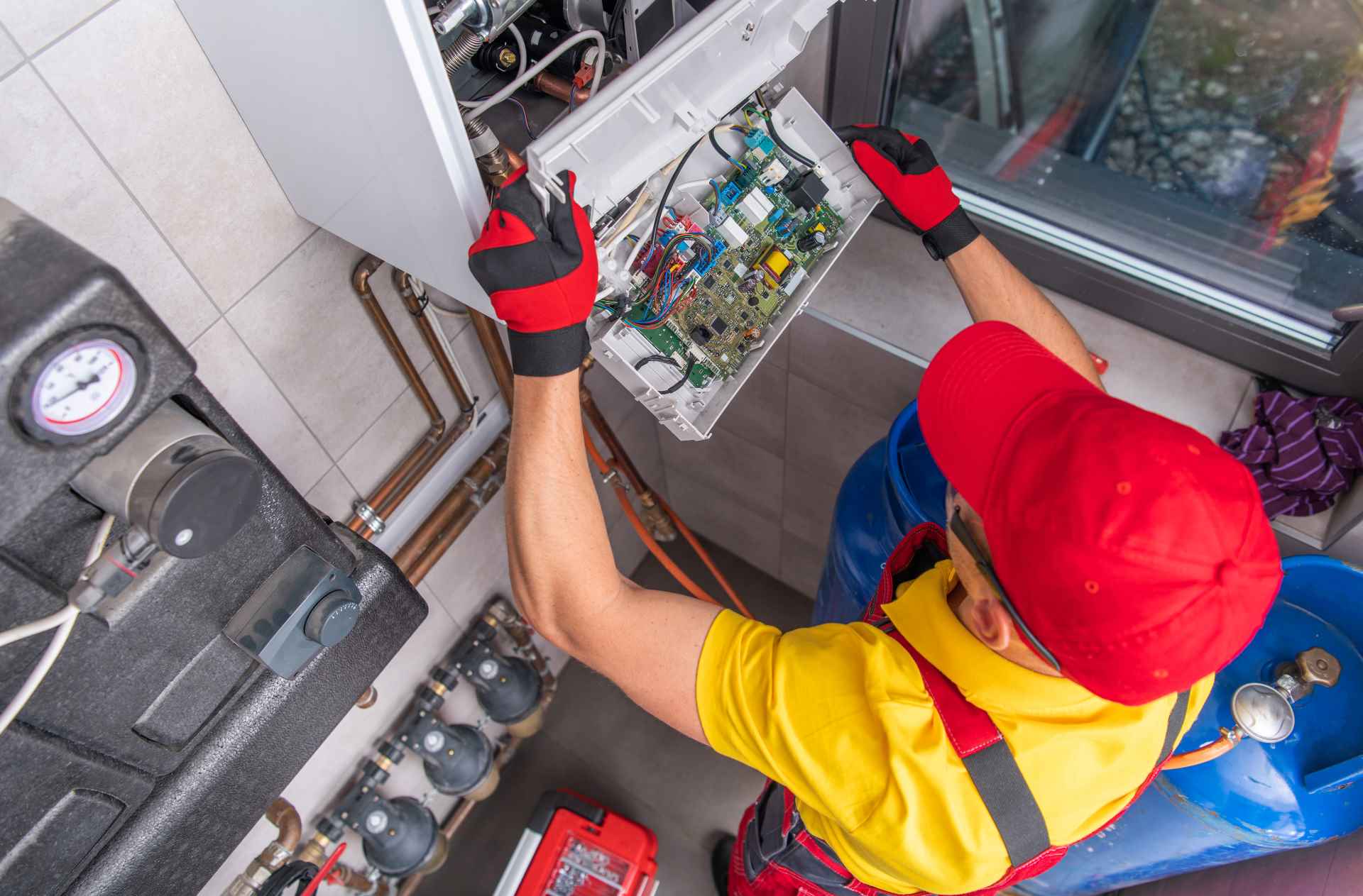 Plumber working on a gas hot water system | Featured image for the Different Types of Hot Water Systems blog from Akins Plumbing.