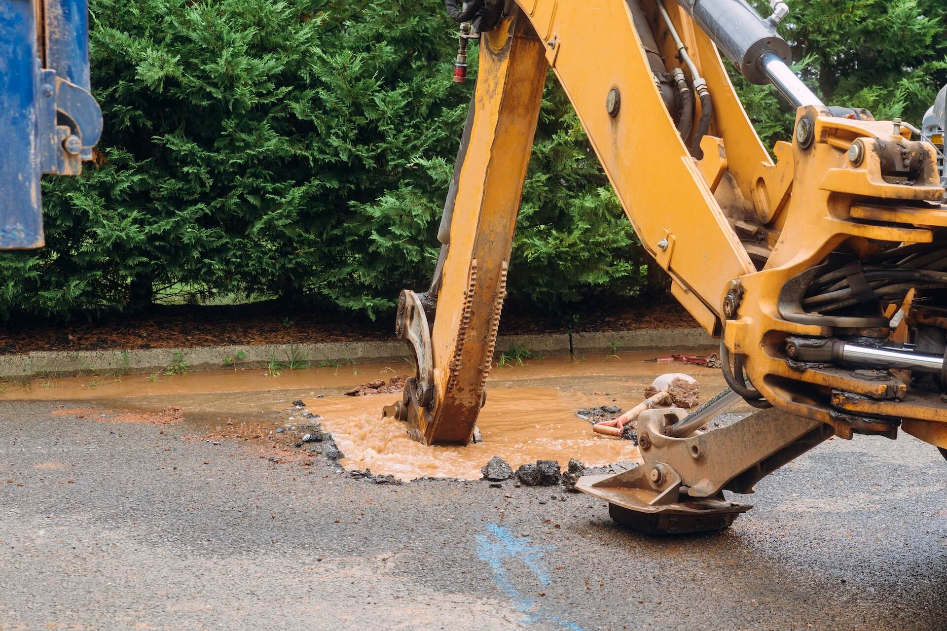 Burst pipes in a city being fixed with a backhoe | Featured image for the Plumbing Repair Services Page from Akins Plumbing.
